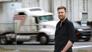 Portrait of Felix Heide with speeding truck blurred in the background.
